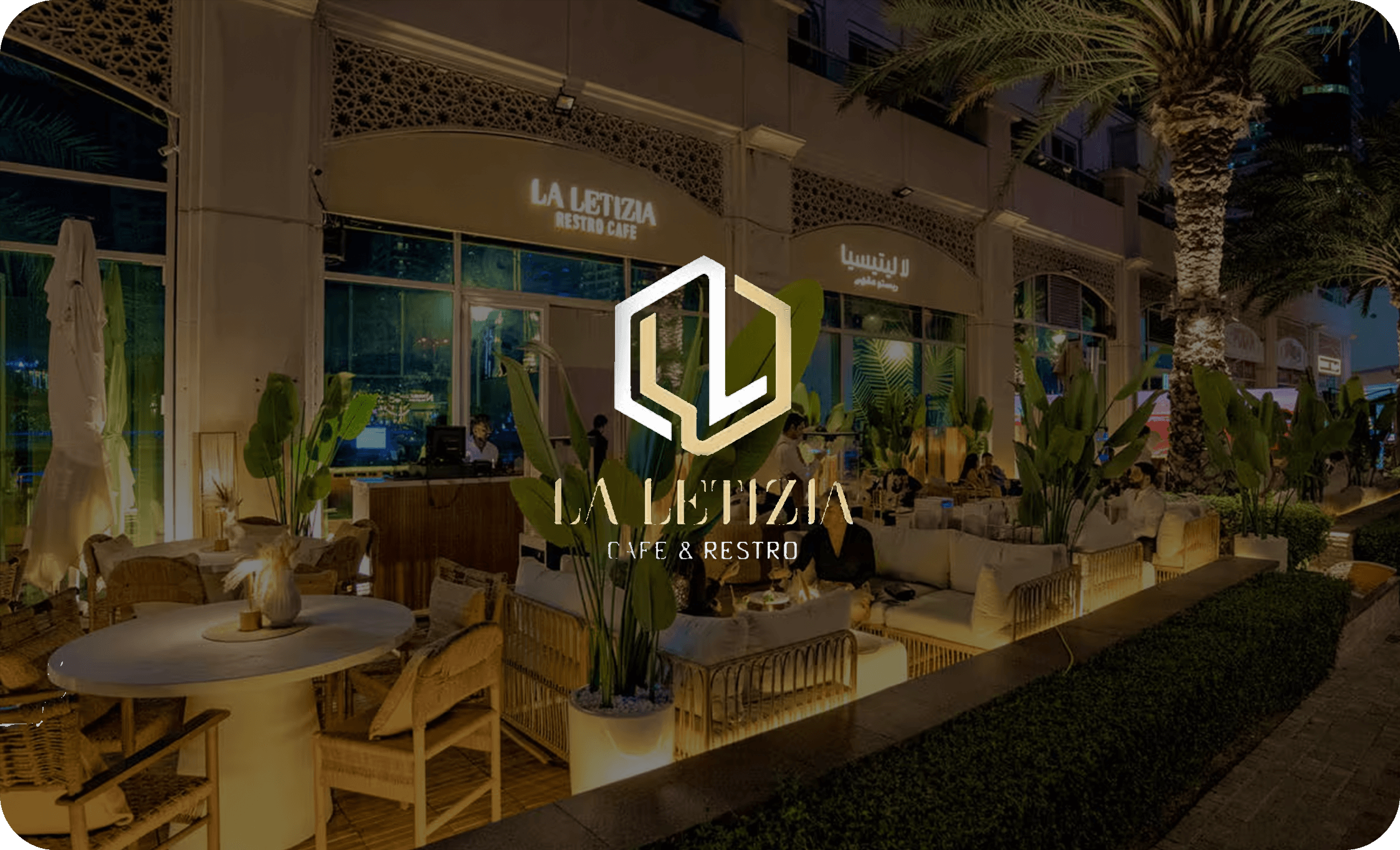 ドバイにあるラグジュアリーなカフェ&レストラン「LA LETIZIA」の夜景外観、テラス席と豊かな緑が印象的